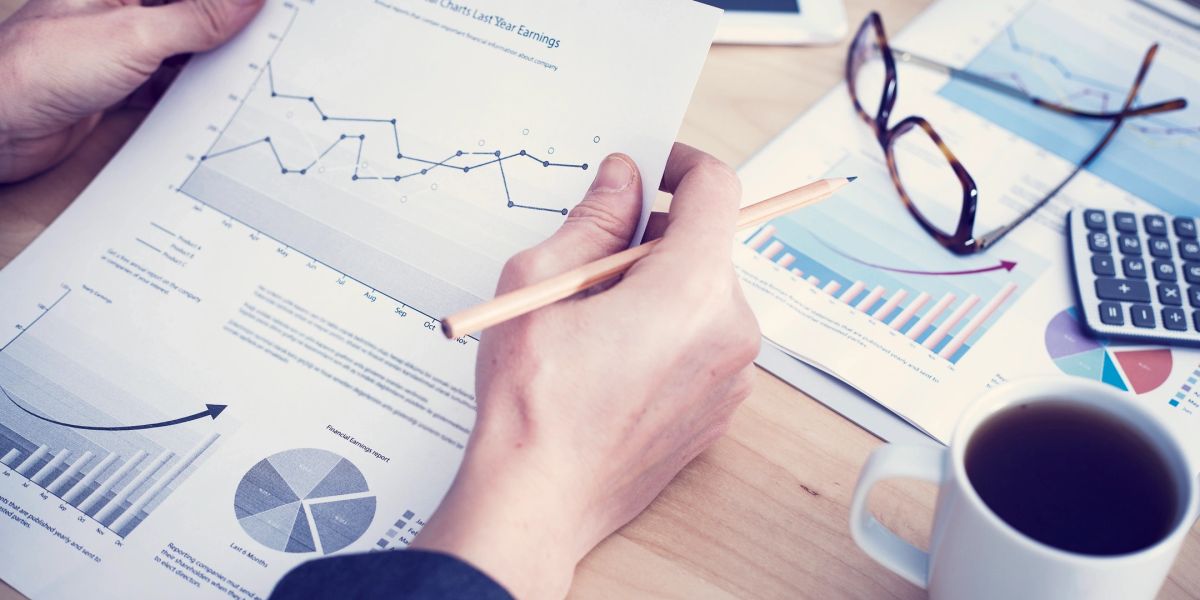 Hands reviewing printed financial reports